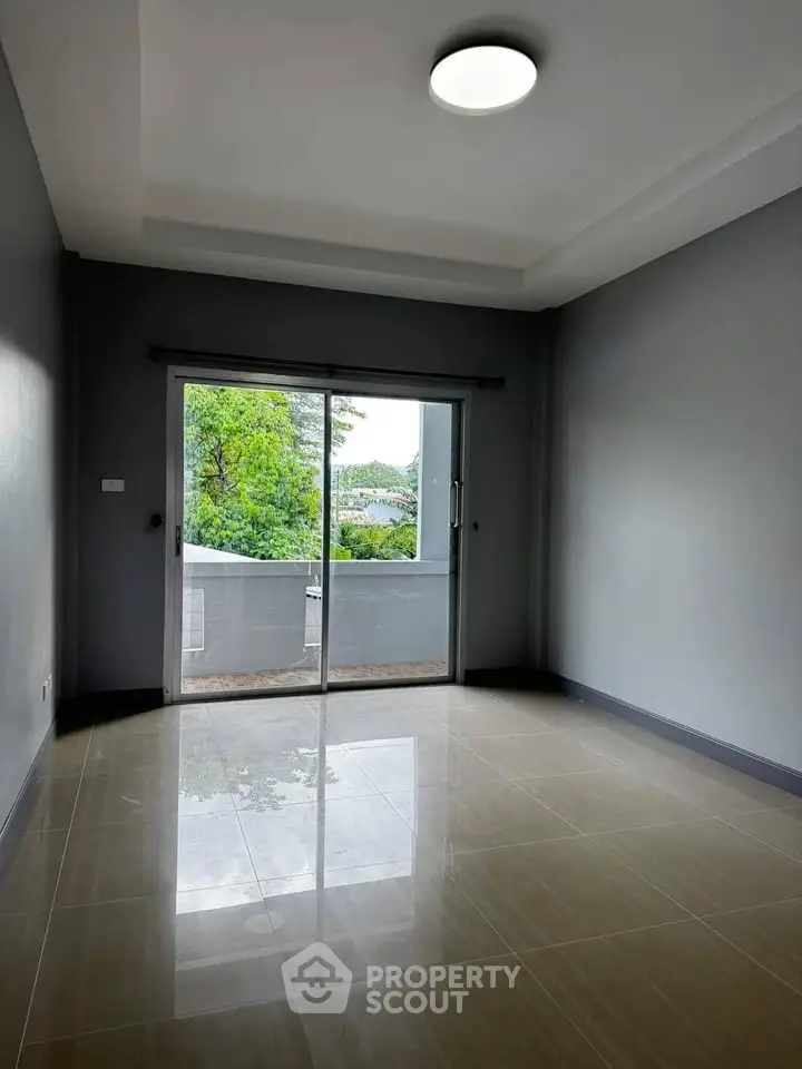 Spacious empty room with large window and balcony view