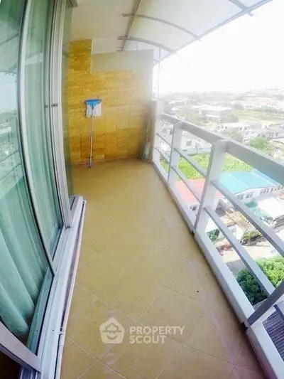 Spacious balcony with city view and glass railing, perfect for relaxation.