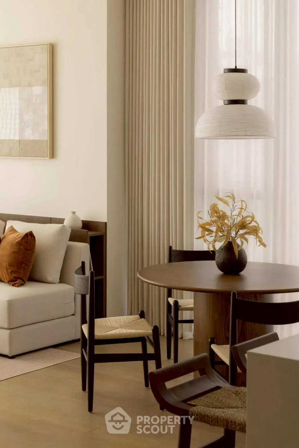 Elegant living room with modern dining area, featuring stylish furniture and warm decor.