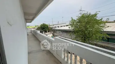 Spacious balcony with urban view and rail tracks, ideal for city living.