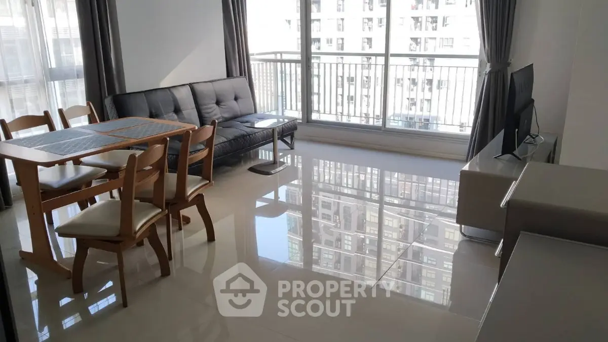 Spacious living room with modern furniture and large windows offering city views.