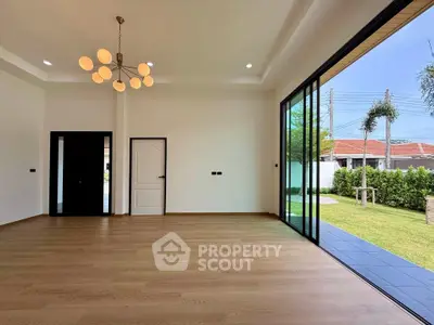 Spacious living room with large sliding glass doors opening to a lush garden.