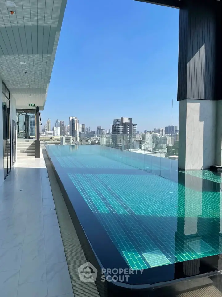 Luxurious rooftop infinity pool with stunning city skyline views, perfect for relaxation and leisure in urban living.