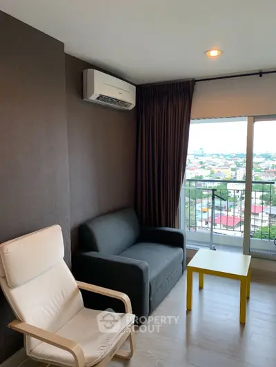Cozy living room with modern furniture, ample natural light, and a city view, perfect for relaxation and entertaining guests.