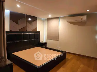 Modern bedroom with stylish bed frame and air conditioning in a cozy setting.