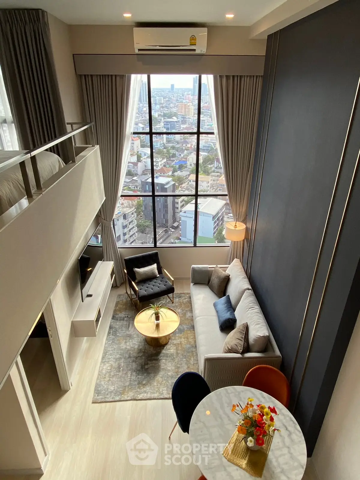 Stunning loft apartment with high ceilings and panoramic city views, featuring modern decor and cozy living space.
