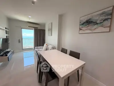 Modern living room with dining area and ocean view balcony in a stylish apartment.