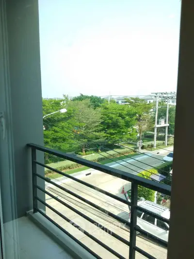 Spacious balcony with scenic view of lush greenery and modern infrastructure.