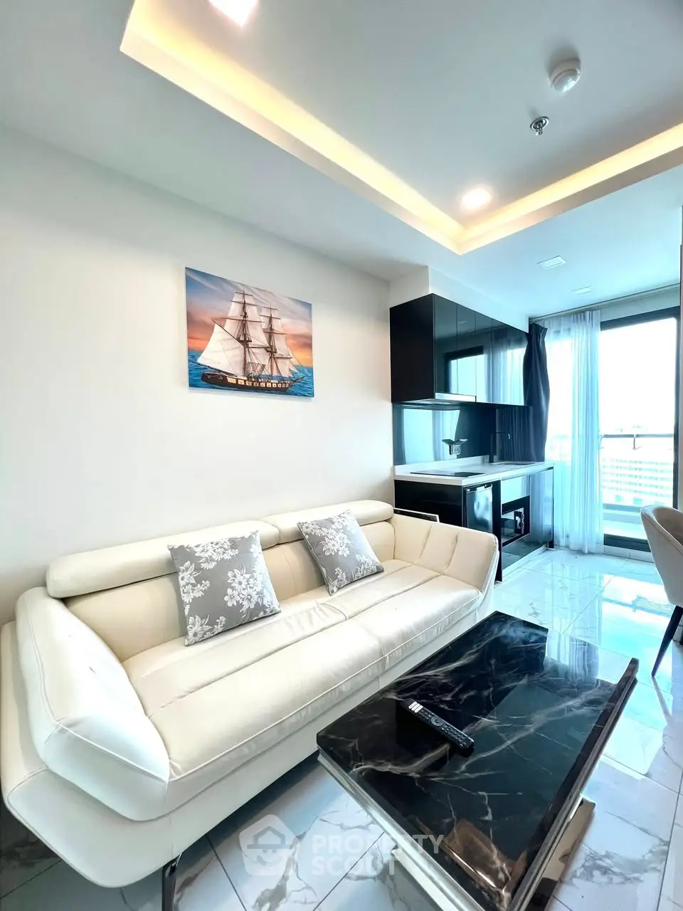 Modern living room with sleek white sofa and marble coffee table in a high-rise apartment.