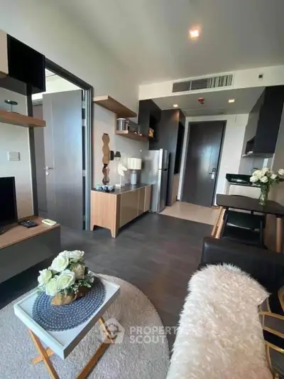 Modern living room with open kitchen, stylish decor, and cozy ambiance in a contemporary apartment.