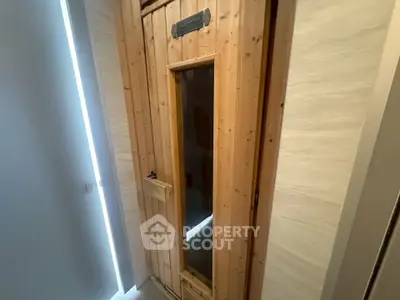 Luxurious home sauna with wooden door and modern design, perfect for relaxation and wellness.