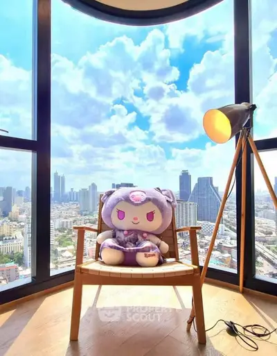Stunning city view from a modern high-rise apartment with plush seating and floor lamp.