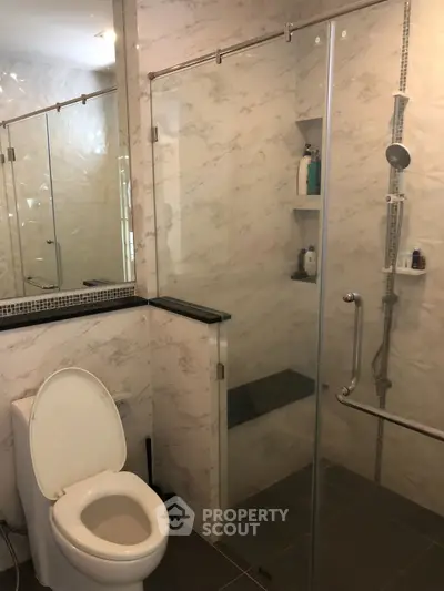 Modern bathroom with glass shower and sleek marble walls