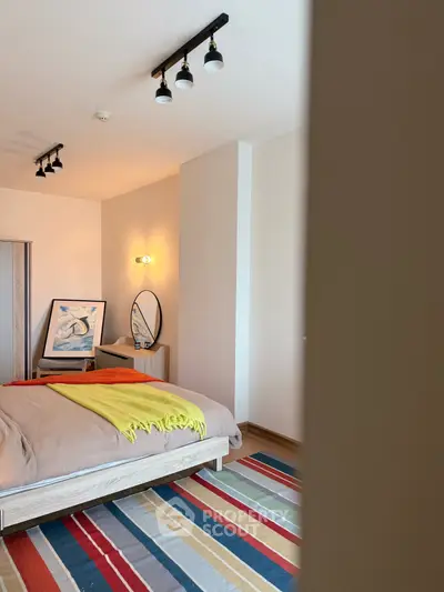 Modern bedroom with colorful striped rug and stylish lighting