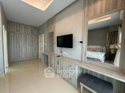 Spacious bedroom with modern built-in wardrobe and wall-mounted TV