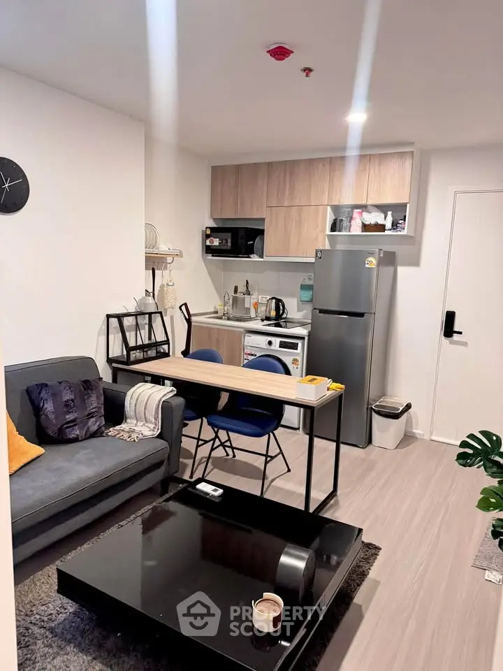 Modern open-plan living room with kitchen, featuring sleek furniture and contemporary design.