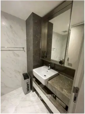 Modern bathroom with sleek marble finishes and stylish sink design.