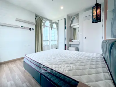 Chic bedroom with elegant decor and large windows offering city views, perfect for urban living.