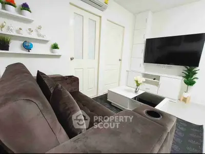 Modern living room with plush sofa, wall-mounted TV, and stylish decor in a cozy apartment.