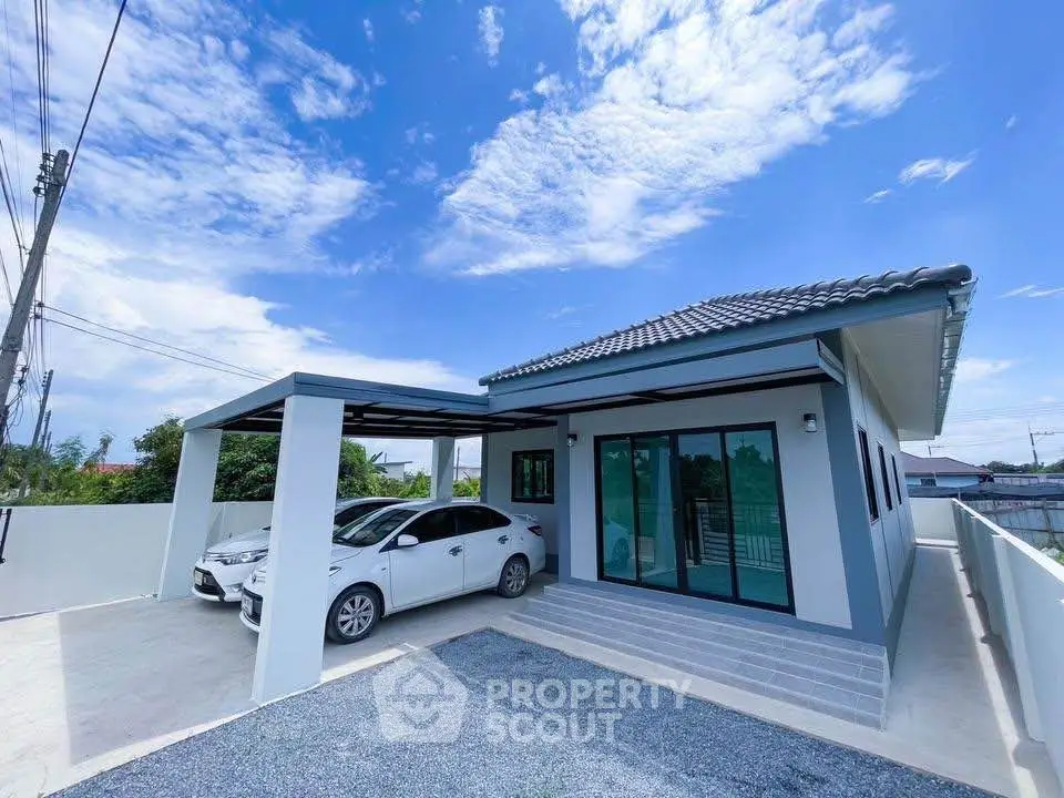 Modern single-story house with carport and sleek design under a clear blue sky.