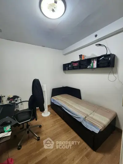 Cozy small bedroom with single bed and study desk, perfect for compact living.