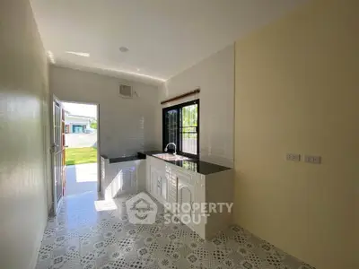 Bright kitchen with open layout and modern design, featuring sleek countertops and ample natural light.