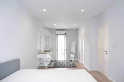Spacious modern bedroom with minimalist design and ample natural light.