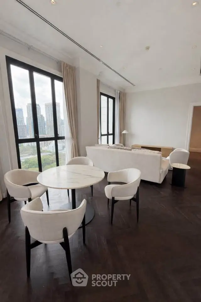 Luxurious living room with city view, elegant furniture, and large windows.