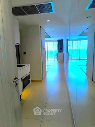 Sleek modern apartment hallway with mirrored walls and bright natural light