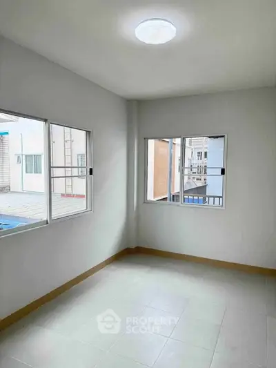 Bright empty room with large windows and tiled floor, perfect for customization.