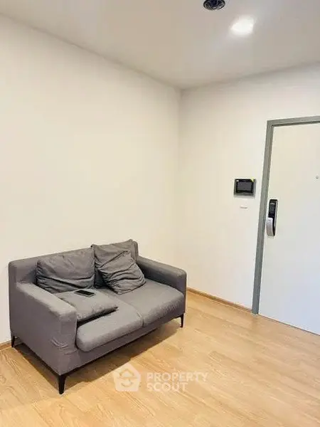 Cozy living room with modern gray sofa and wooden flooring, perfect for relaxation.