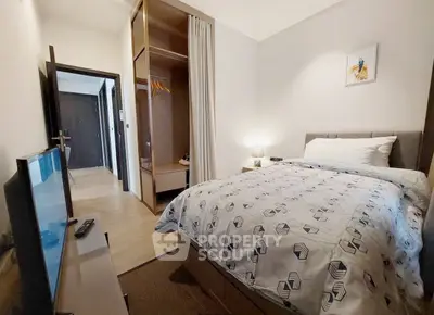 Cozy bedroom with modern decor and ample storage in a stylish apartment.