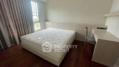 Spacious bedroom with polished wooden flooring, large windows draped in elegant curtains, and a minimalist design awaiting personal touches.