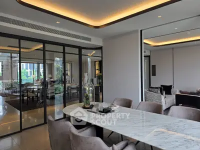 Luxurious modern dining area with marble table and elegant chairs in open-plan living space.