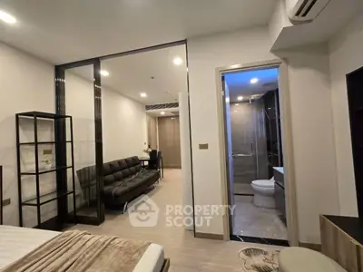 Modern apartment interior with living room and bathroom, featuring sleek design and neutral tones.