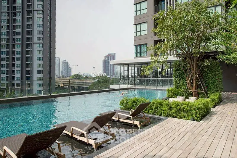 Luxurious rooftop pool with city skyline view and modern lounge chairs.