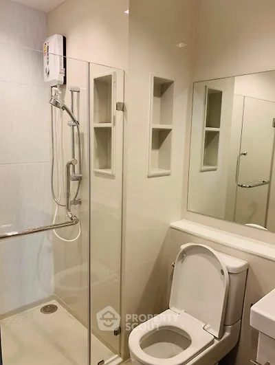 Modern bathroom with glass shower and sleek fixtures in a contemporary apartment.