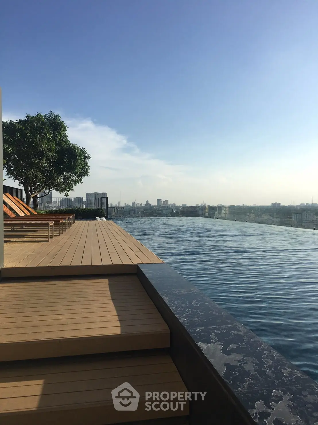 Luxurious rooftop infinity pool with stunning city skyline view, perfect for relaxation and leisure.