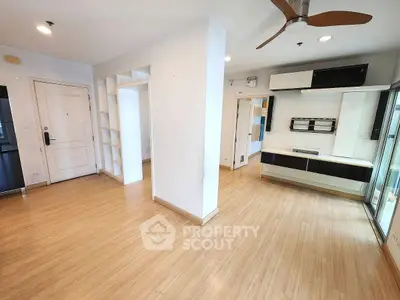 Spacious modern living area with wooden flooring and built-in storage, perfect for urban living.