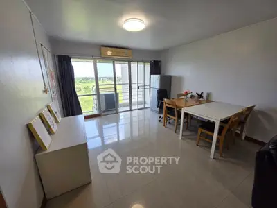 Spacious living room with dining area and balcony view in modern apartment