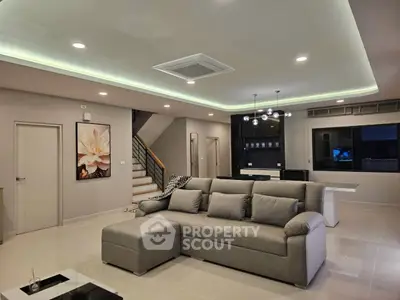 Spacious modern living room with elegant lighting and stylish furniture, perfect for family gatherings.