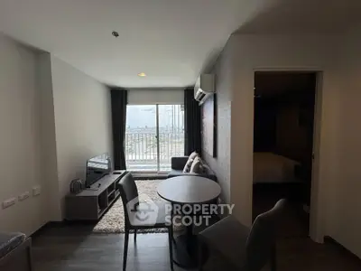 Modern living room with city view, cozy seating, and dining area in a stylish apartment.