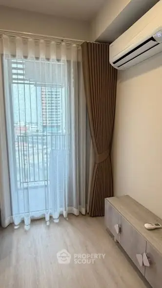 Modern apartment interior with air conditioning and balcony view, featuring elegant curtains and wooden flooring.