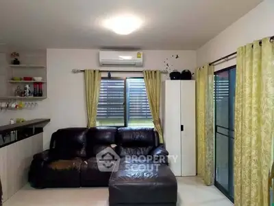 Cozy living room with leather sofa and air conditioning, perfect for relaxation.