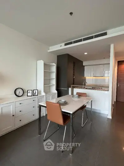 Modern dining area with sleek kitchen in open layout apartment