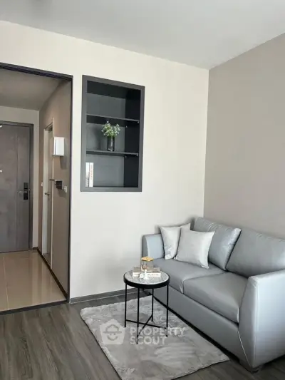 Modern living room with sleek gray sofa and stylish decor in a contemporary apartment.