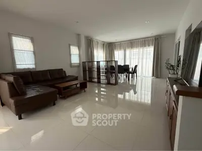 Spacious modern living room with sleek furniture and large windows for natural light.