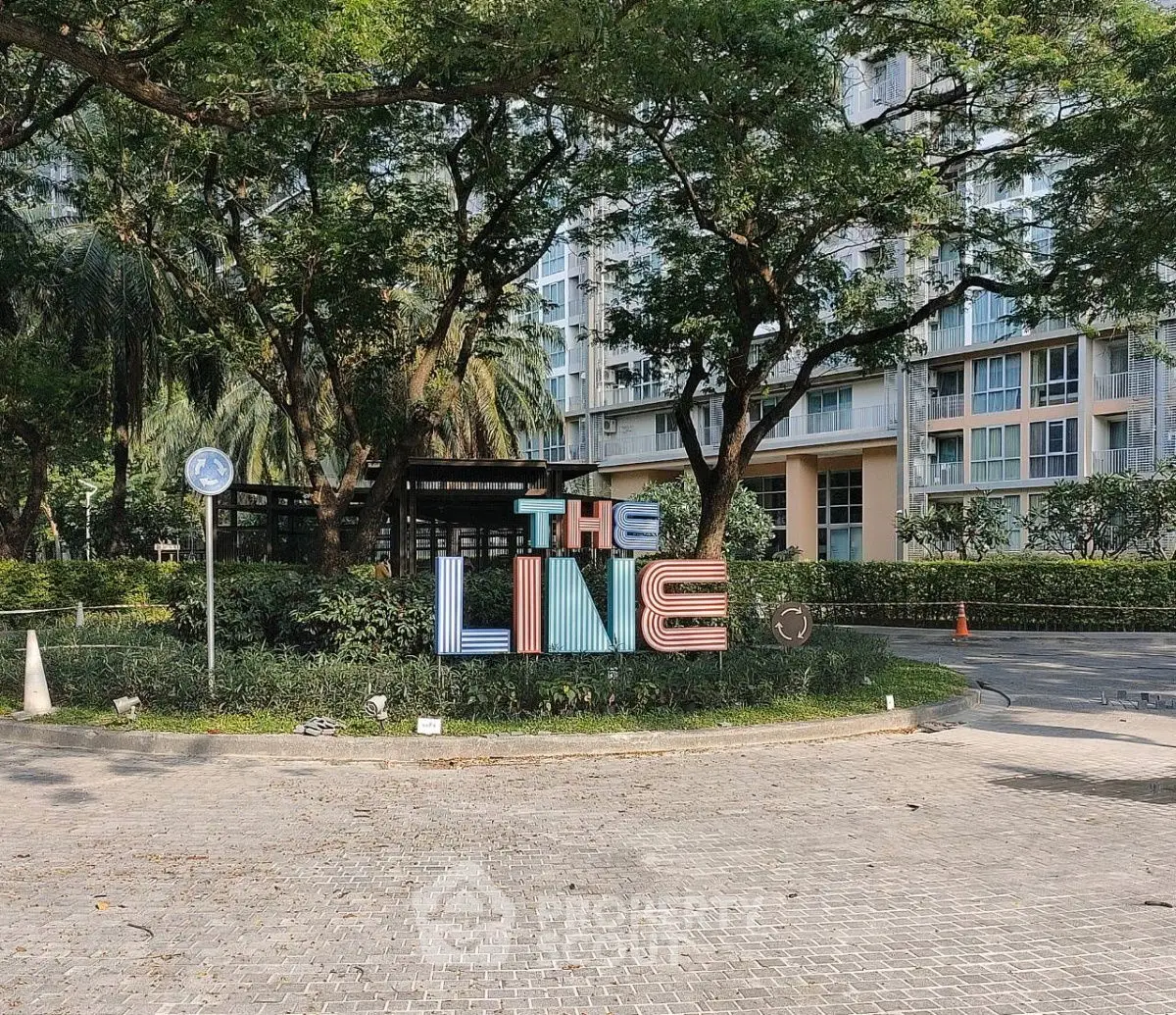 Modern residential building with lush greenery and stylish entrance sign.