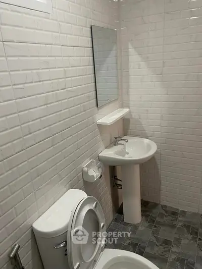 Modern bathroom with white brick tiles and sleek fixtures