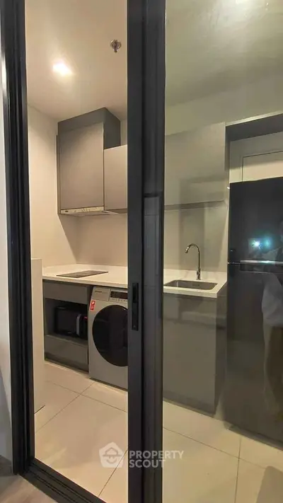 Modern kitchen with sleek appliances and minimalist design in a contemporary apartment.